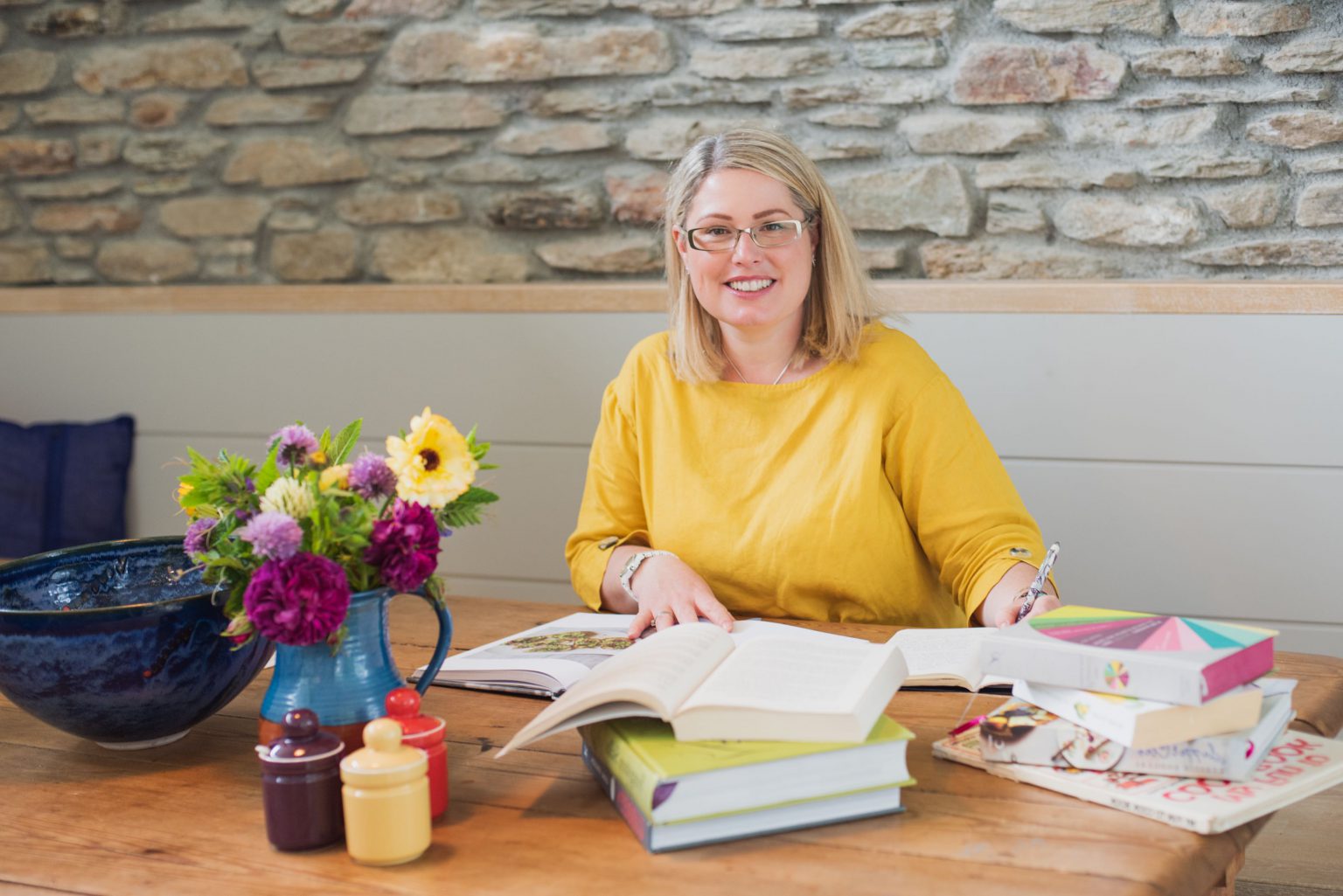 Kate writing at table with books around her